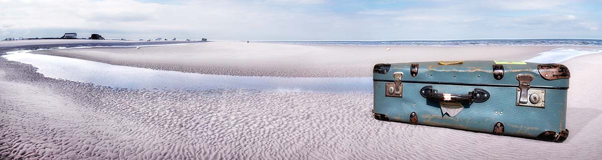 header_kundenstimmen_39955791 Koffer am Strand